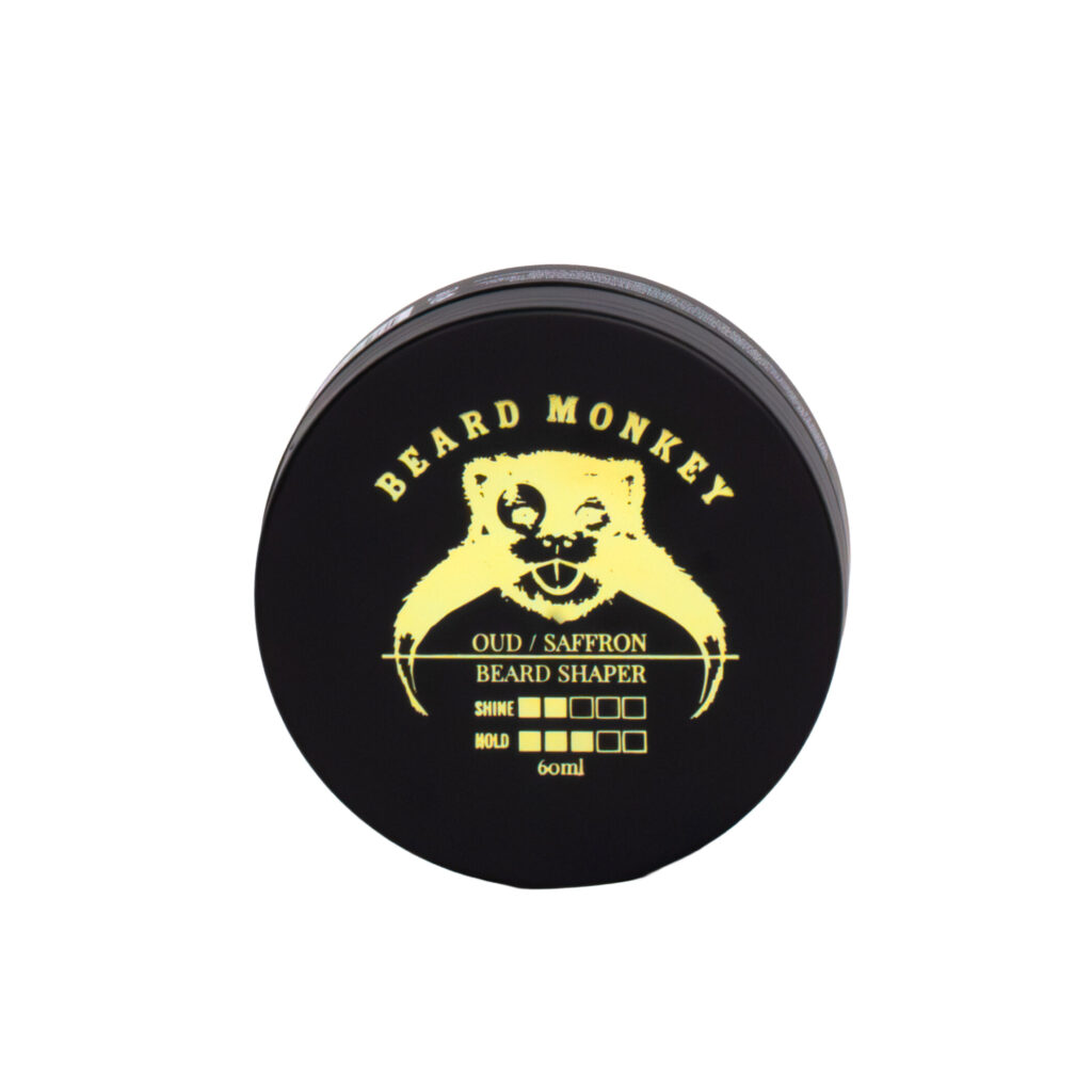 Beard Monkey skäggvax Oud/Saffron i en svart burk om 60ml med gula detaljer.