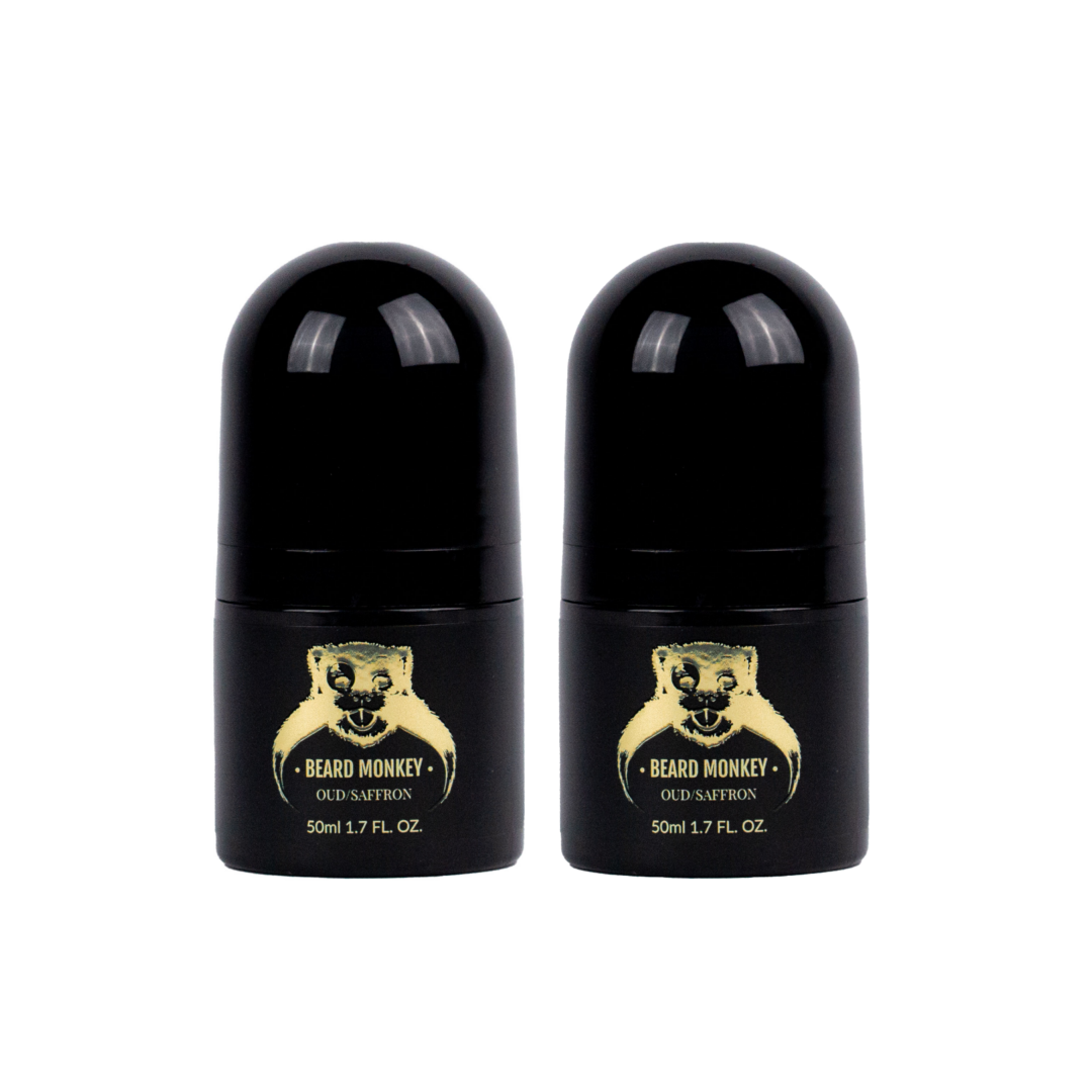 Två svarta cylindriska deodoranter med guldiga detaljer märkta "Beard Monkey Oud/Saffron" och med apa som logotyp.