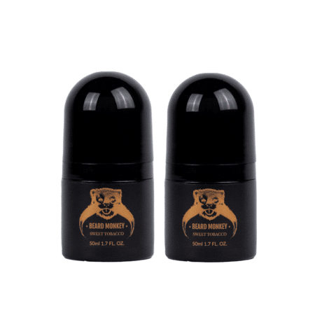 Två svarta cylindriska deodoranter med bronsfärgade detaljer märkt "Beard Monkey Sweet Tobacco" med apa som logotyp.