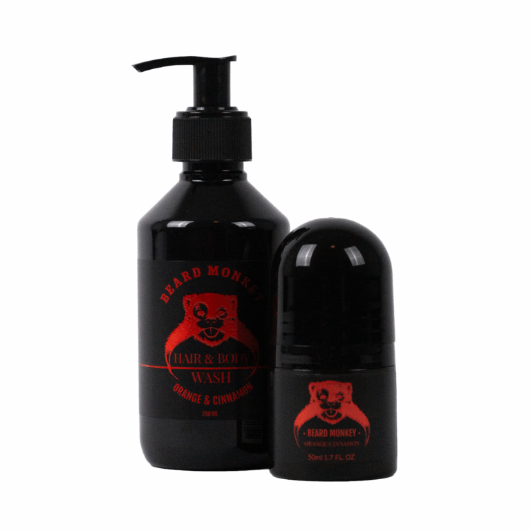 Två produkter från Beard Monkey i doften Orange/Cinnamon – en svart pumpflaska med Hair & Body Wash (250 ml) och en matchande svart deodorantroll-on (50 ml), båda med rött tryckt logotyp och etikett.
