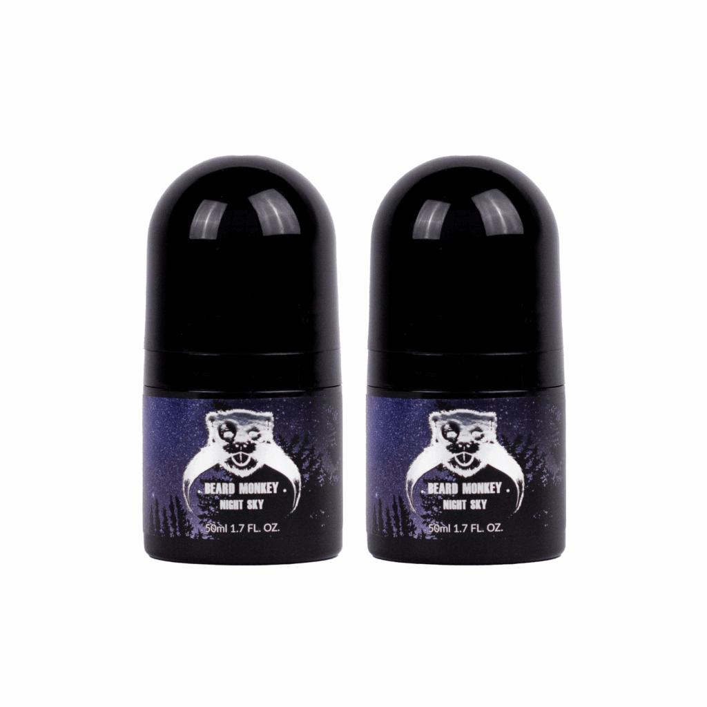 Två svarta cylindriska deodoranter med etiketter som har bild på en stjärnhimmel som bakgrund. Produkterna har vita detaljer och är märkt "Beard Monkey Night Sky" med apa som logotyp.
