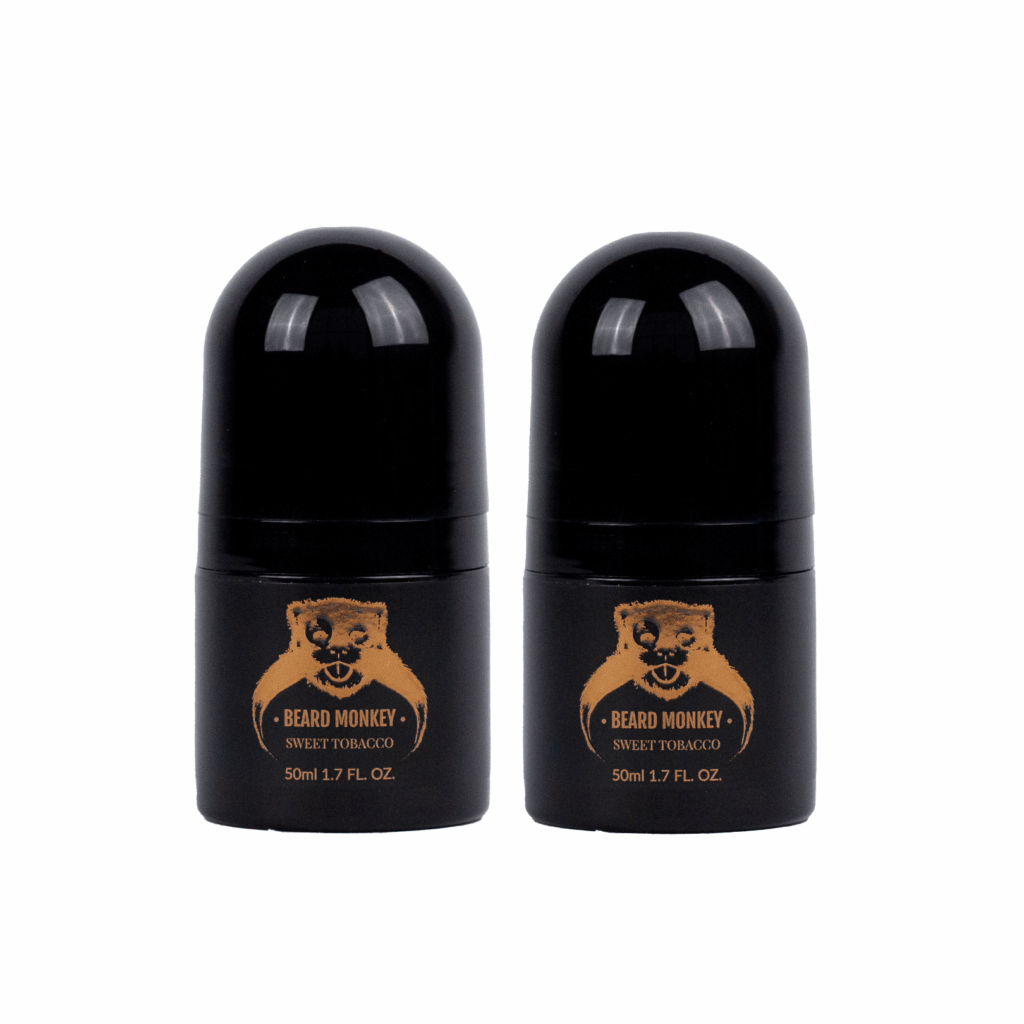 Två svarta cylindriska deodoranter med bronsfärgade detaljer märkt "Beard Monkey Sweet Tobacco" med apa som logotyp.